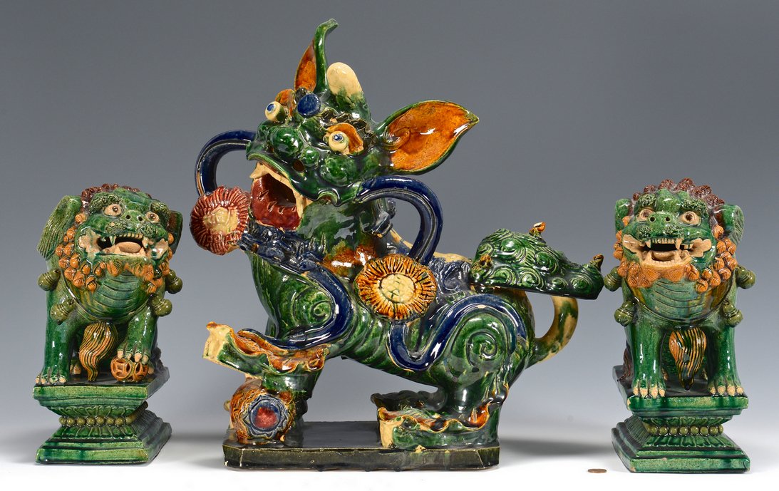 3 Buddhist Lion Pottery Figures: Three large Chinese Sancai glazed Buddhist temple lions. Includes one pair of lions (also called foo dogs), atop plinths, 11"H overall, and one large, colorfully glazed lion or dragon figure with bare