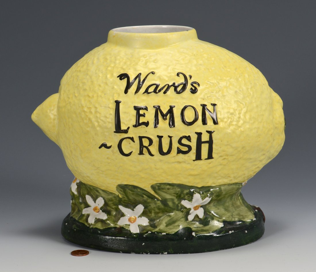 Ward's Lemon Crush Countertop Syrup Dispenser: Ward's Lemon Crush countertop ceramic syrup dispenser, in the form of a lemon atop a floral and green base. Base impressed T700S. Measurements without top - 9" H x 11" W. Circa 1920's.