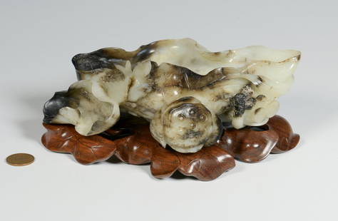 Carved Jade Brush Washer, Lotus Form: Chinese Qing Dynasty white and gray/black nephrite brushwasher bowl (also known as chicken bone jade); elaborately carved in a lotus leaf form with bird or phoenix, fruit and leaf decoration along