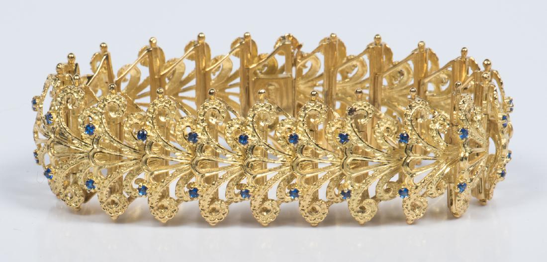 Brazilian 18K Link Bracelet: 18K yellow gold bracelet of satin and bright finish links of pierced scrolled palmettes, each link highlighted with two small faceted sapphires, 44 sapphires total. Stamped on clasp: 750 37 AR. 7-3/8"