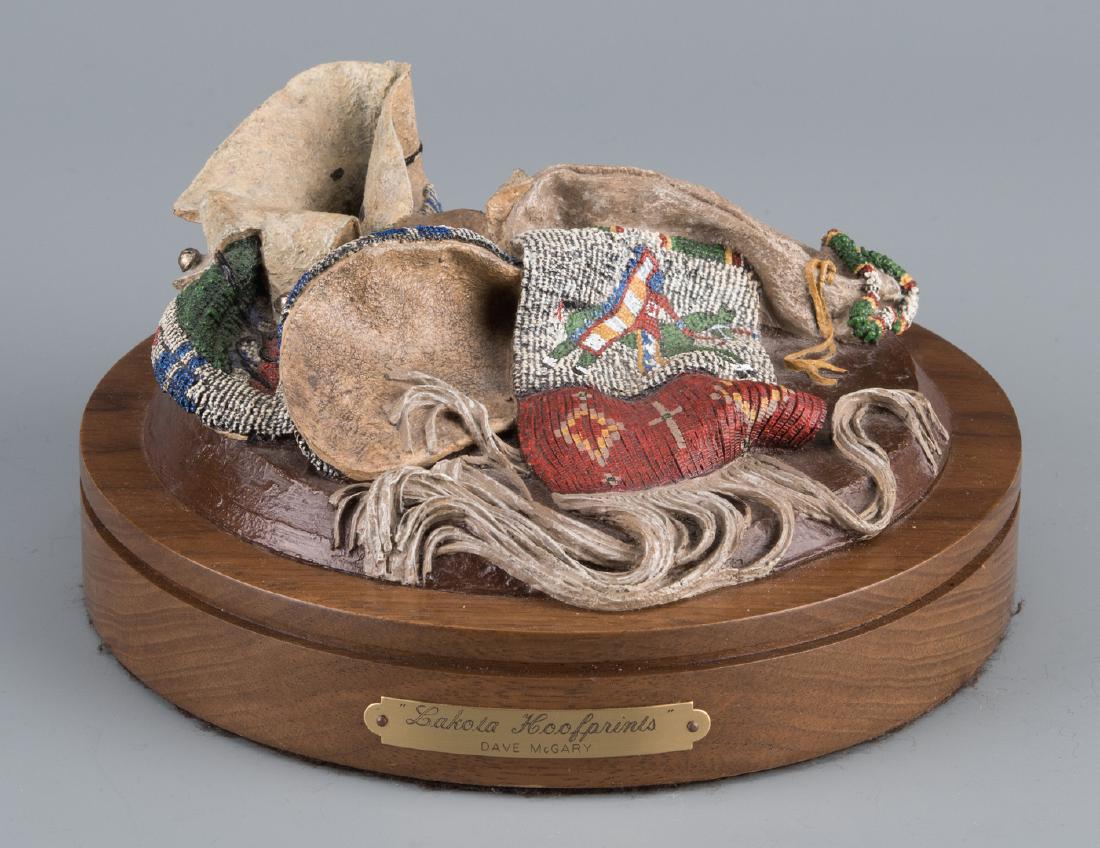 Dave McGary Bronze Sculpture "Lakota Hoofprints": David McGary (American, b. 1958) patinated and painted bronze sculpture titled "Lakota Hoofprints" depicting beaded moccasins and a pipe bag. Signed, dated, and numbered "Dave McGary 1996 140/250" bac