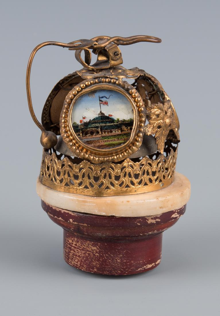 World's Fair Bell, 1894 San Fran: Souvenir table bell from the San Francisco Mid Winter Exhibition of 1894, with 3 eglomise vignettes depicting various buildings, and a gilt metal filigree frame affixed to a round marble disc. 3"H. (A