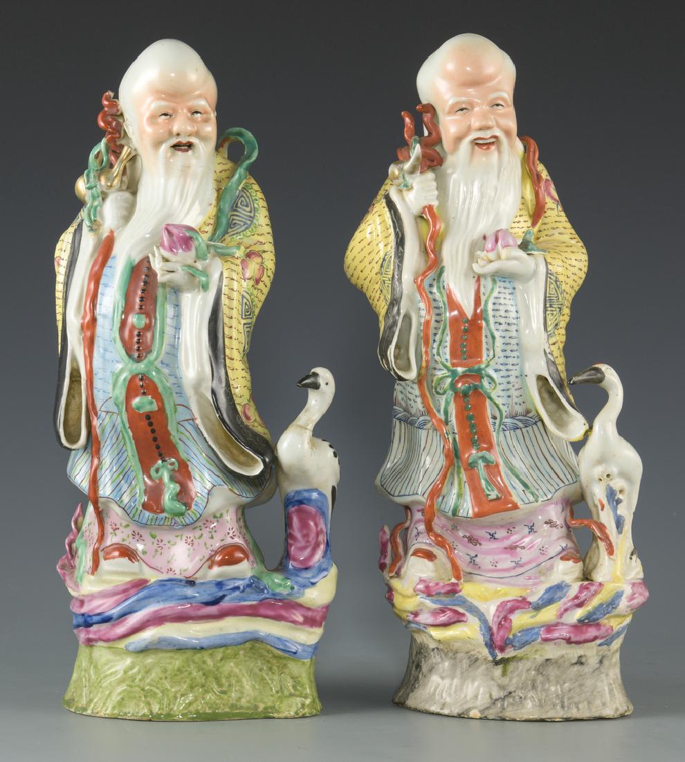 2 Chinese Porcelain Longevity Figures: 2 Chinese Famille Rose porcelain immortal figurals, both depicting Shou Xing, the God of Longevity. Each is depicted standing on a rocky base with a crane, holding a long knotted staff and pumpkin gou