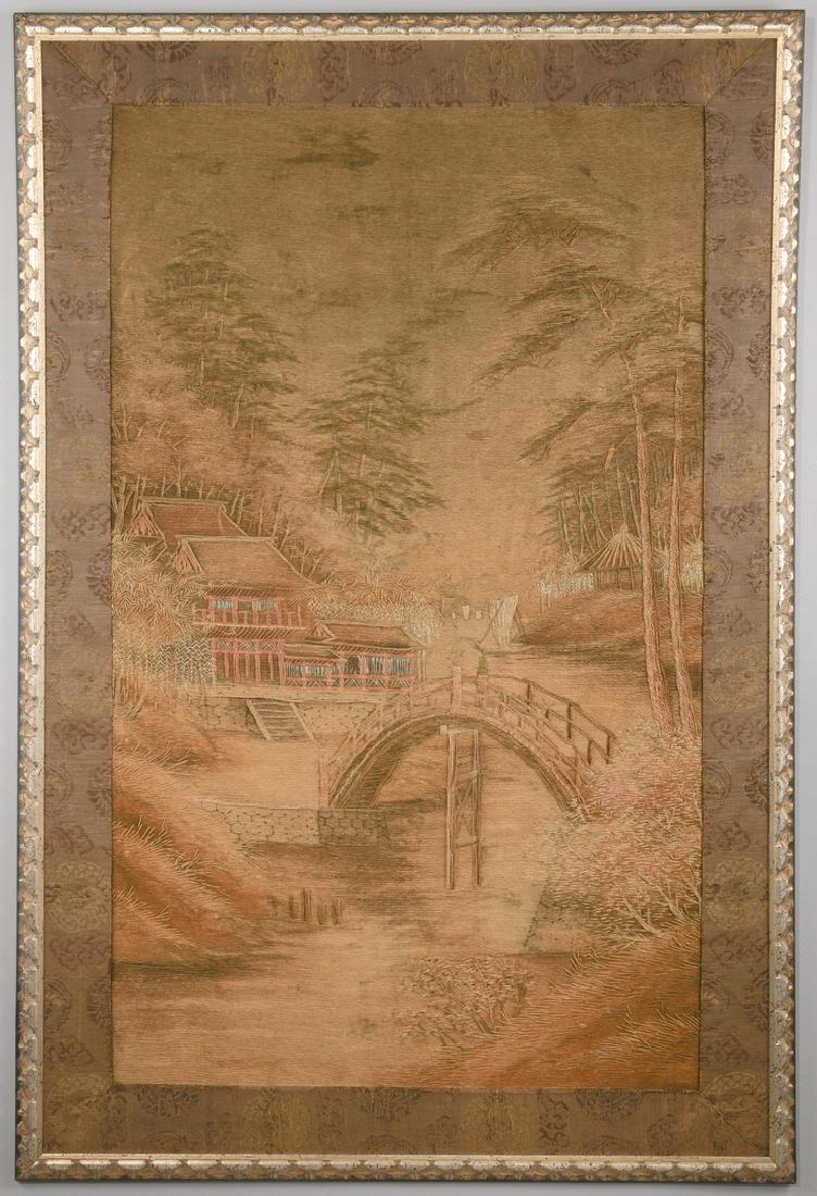 Meiji Embroidered Landscape Panel: Large Japanese silk embroidered landscape panel with arched bridge over stream, buildings to left and right, boat in the distance and forest in background. Textile is framed in a silver-gilt Louis XII