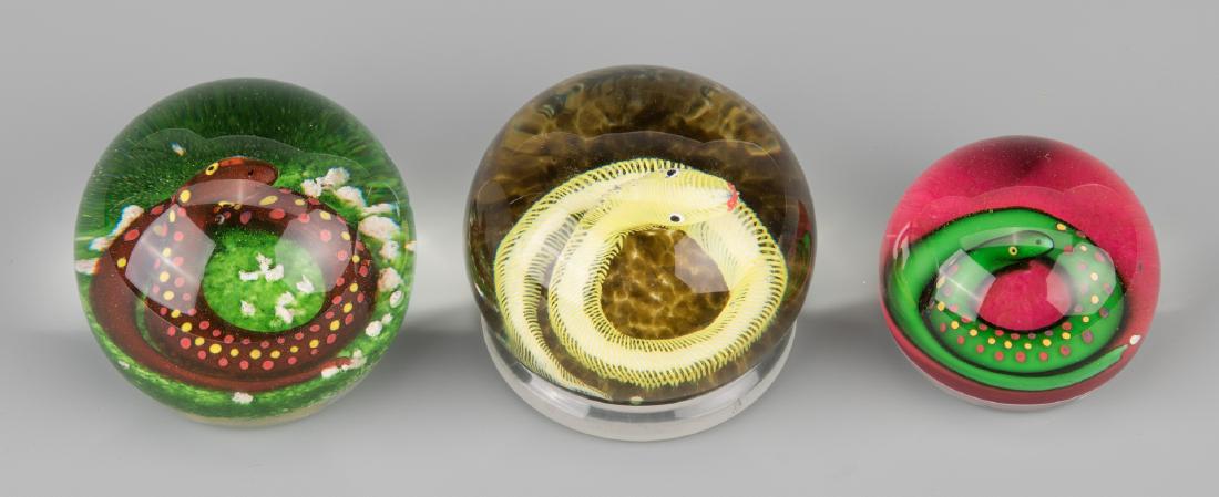3 Paul Ysart Paperweights, Coiled Snakes: Grouping of three Paul Ysart "snake" paperweights including a yellow spiral snake on mottled brown ground (3 1/2" dia), brown dotted snake on green ground (3 1/4" dia) and green dotted snake on pink g