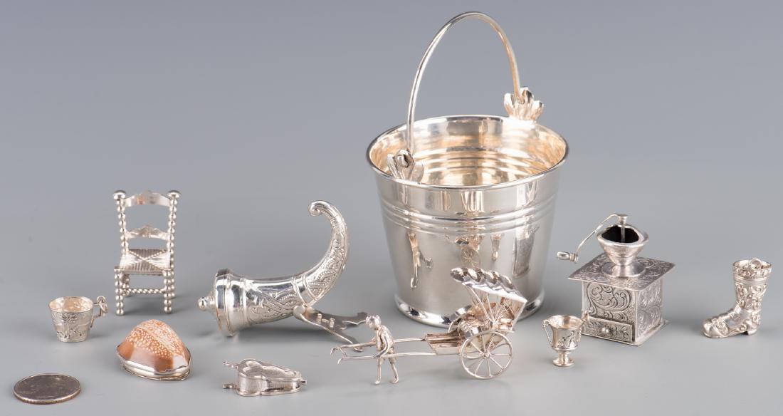 10 Miniature Silver Novelty Items: 10 silver novelty items. Includes a miniature Coffee Grinder marked 835; a miniature Chair marked "CM" with other illegible hallmarks; Boot charm (marked 800); Bellows (marked HH, 835); Rickshaw, mark