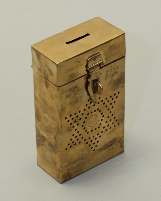 Judaic synagogue brass charity box: engraved with Hebrew, engraved Manhattan New York Dec. 1936, 6.10in(H) x 3.54in(L) x 1.81in(W); Notice to bidders: Measurements are approximate. Condition reports and additional photographs are provid