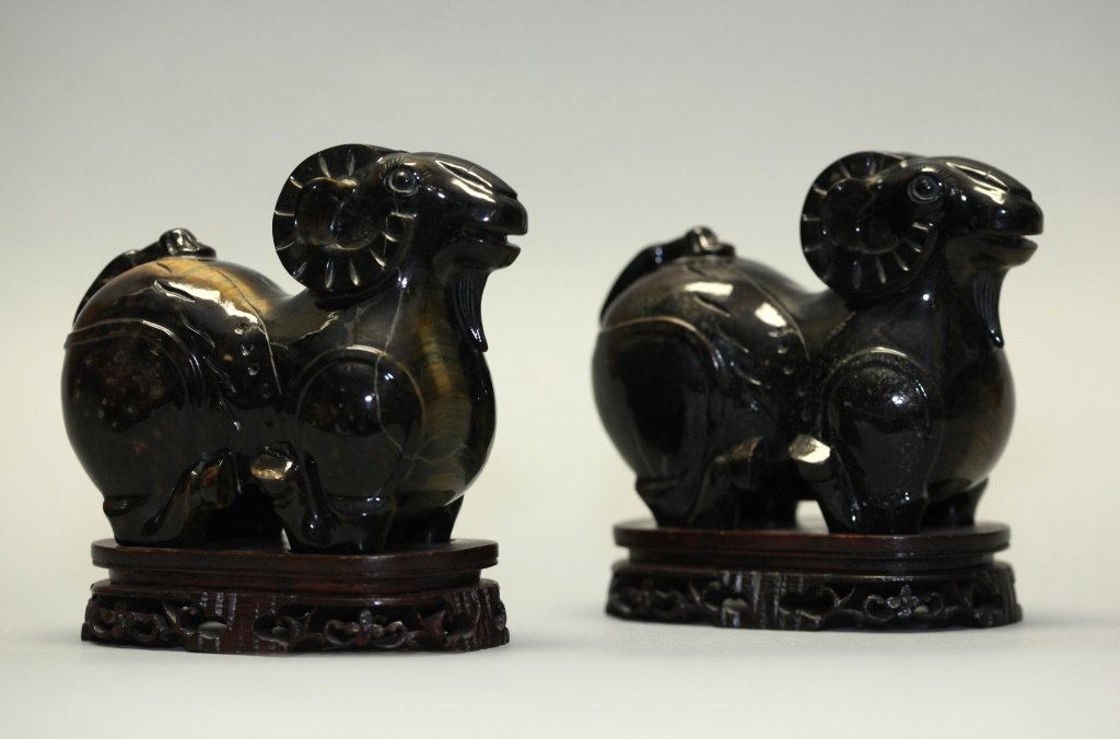 pair of Chinese tiger eye rams: with original base, without base: 4.53in(L) x 3.74in(H) x 2.13in(W); Notice to bidders: Measurements and weights are approximate. Condition reports and additional photographs are provided upon request