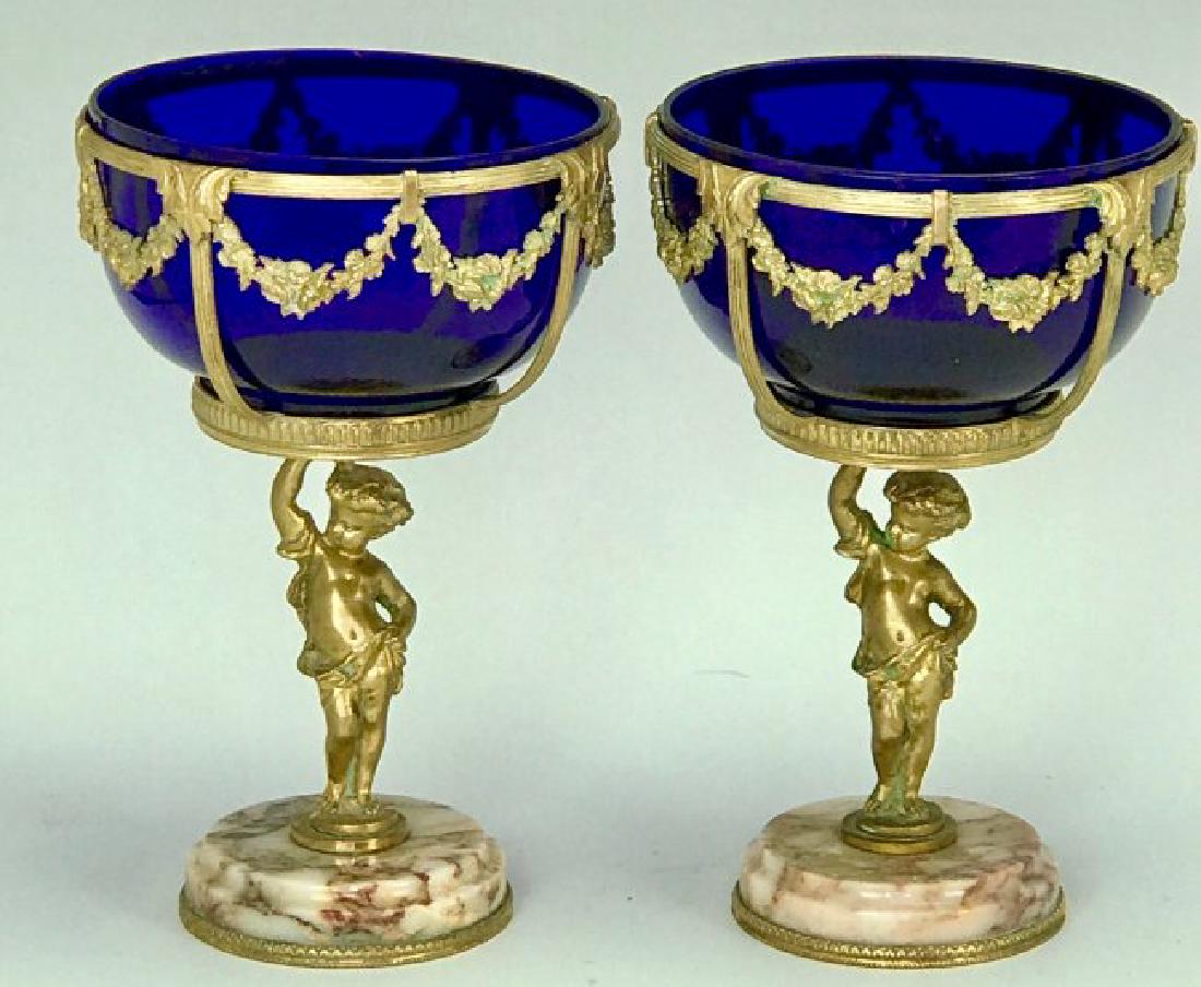 A PAIR OF ORMOLU AND MARBLE FOOTED BOWLS: Circa 1900. Inset with blue glass liners. Excellent condition. Estimate $800-1.000