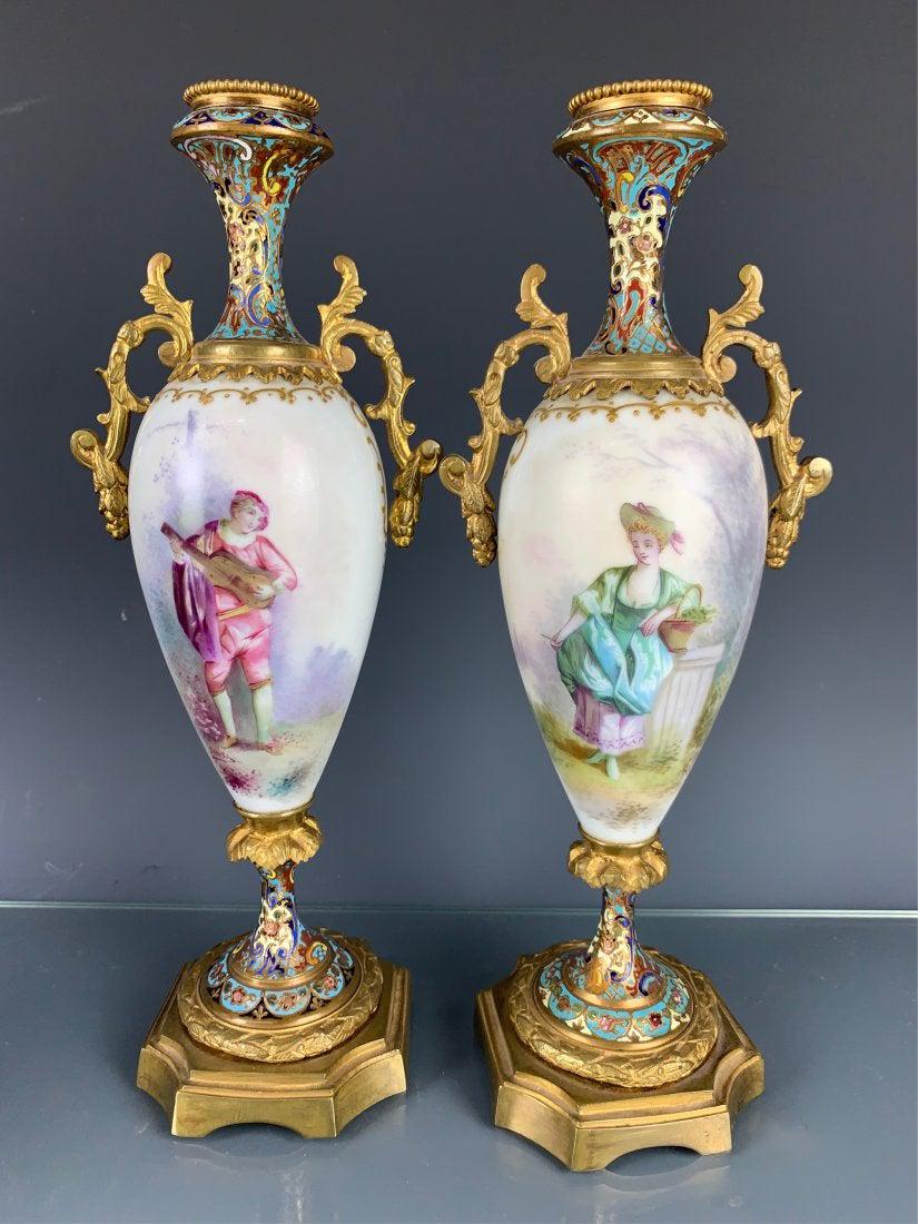 A PAIR OF CHAMPLEVE ENAMEL AND SEVRES VASES: Circa 1900. Measure 10 inches high. Good condition. Estimate $1.000-1.200