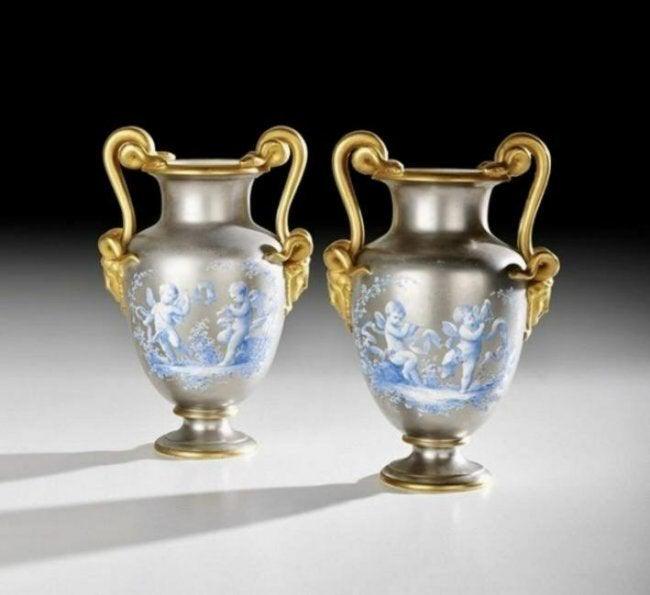 PAIR OF 19TH C. PLATINUM GROUND PORCELAIN VASES: Pair of French Hand-Painted Platinum-Ground Porcelain Urns, fourth quarter 19th century, in the Neo-Grec taste, decorated with blue-painted trophies and allegories of music, with gilt snake-form handl