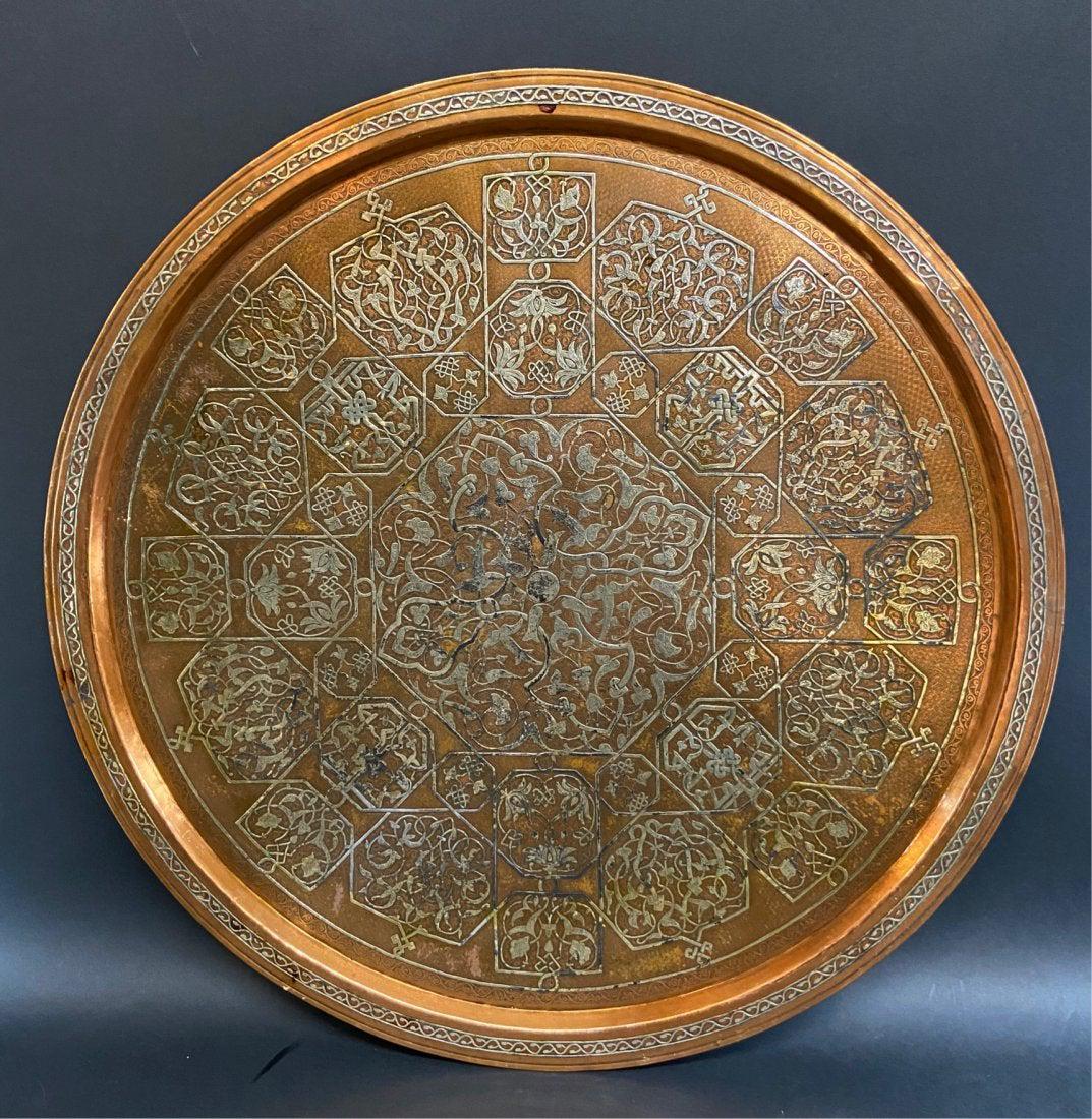 A LARGE ISLAMIC SILVER INLAID COPPER TRAY: Circa 1900. Measures 26 inches diameter. Good antique condition. Estimate $1.200-1.500