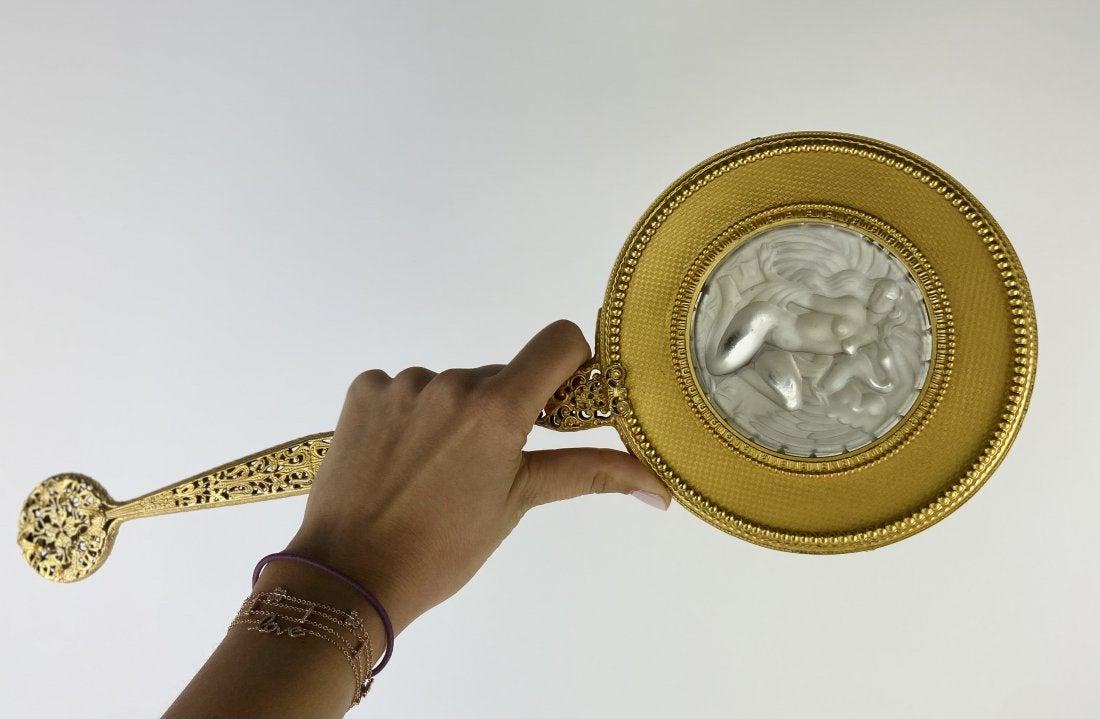 ORMOLU AND MOLDED GLASS MIRROR: Circa 1900. Measures 10.5 inches long. Estimate $500-600