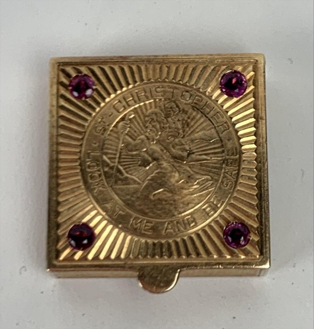 14KT GOLD PILL BOX: yellow gold with panels of engine-turning to the sides and base, the lift-up hinged cover engraved with a medal of Saint Christopher with four rubies to each corner, and engraved to the inside with in