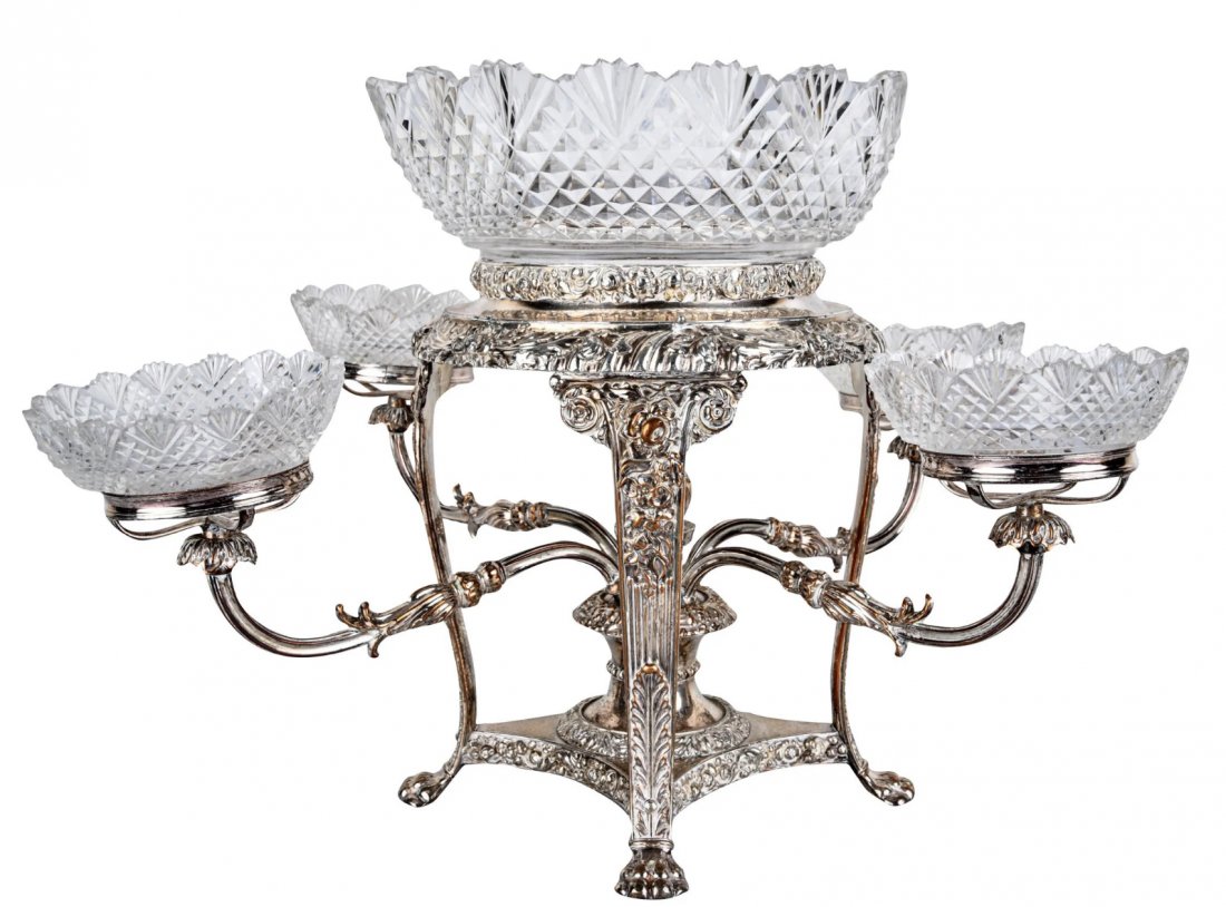 SHEFFIELD SILVERPLATE & CUT GLASS EPERGNE: unmarked with four arms Condition: polish residue throughout. Wear to silvering throughout, revealing copper base metal. One small bowl with extensive repairs. 19 inches wide; 12 inches highEstimate $