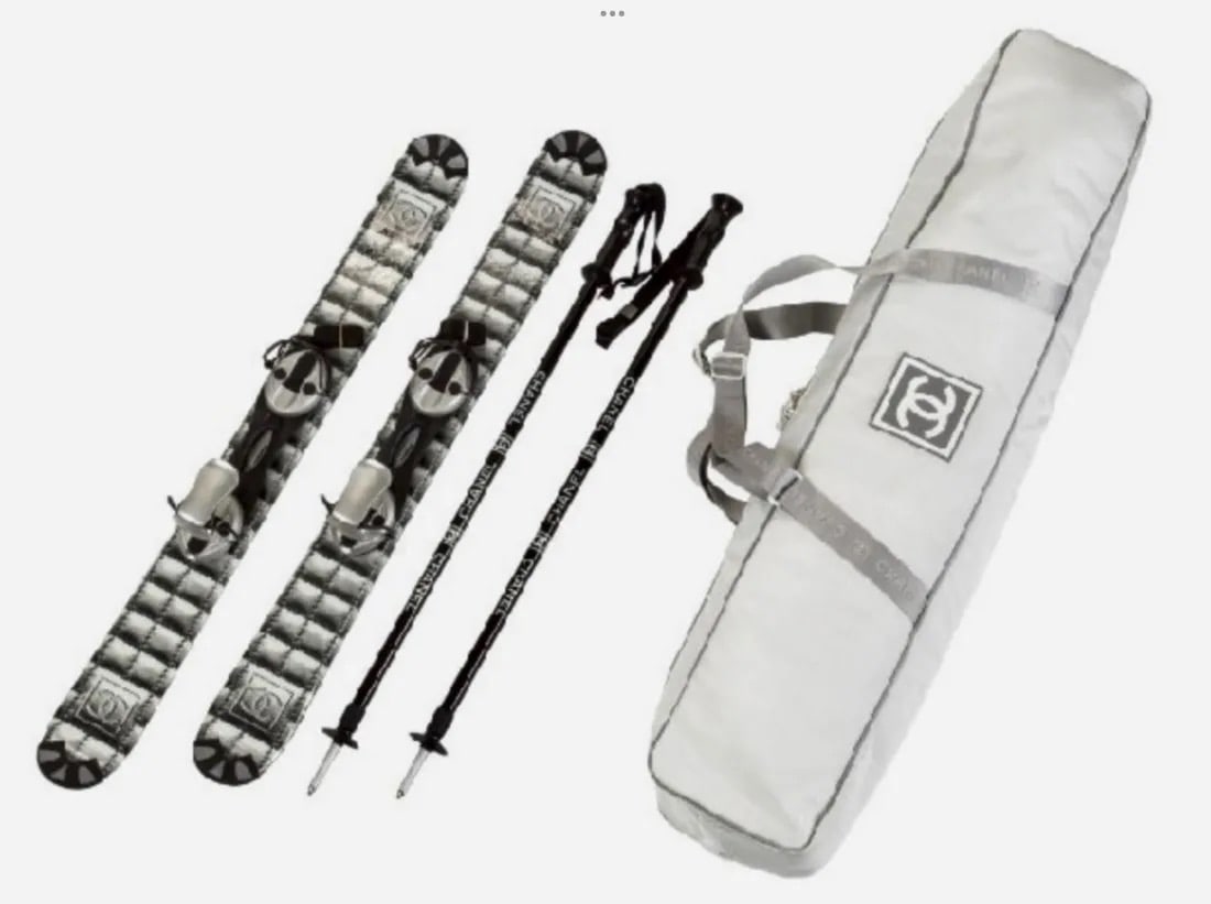 CHANEL BLACK & WHITE CARBON FIBER SKIS & POLES: These collectible Chanel skis are crafted in carbon fiber, featuring black and white shadowed quilting print and 'CC' logo prints along the tops. The skis include black plastic-capped ends, and black
