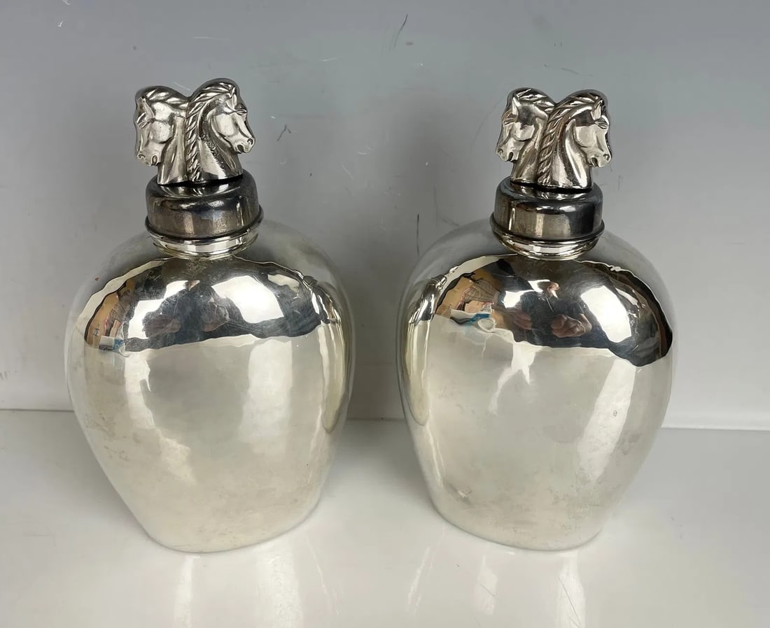 A PAIR OF HAND MADE STERLING SILVER BOTTLES BY ADAM AD,ER: Measure 6.5 inches tall. In good condition. Estimate $500-600