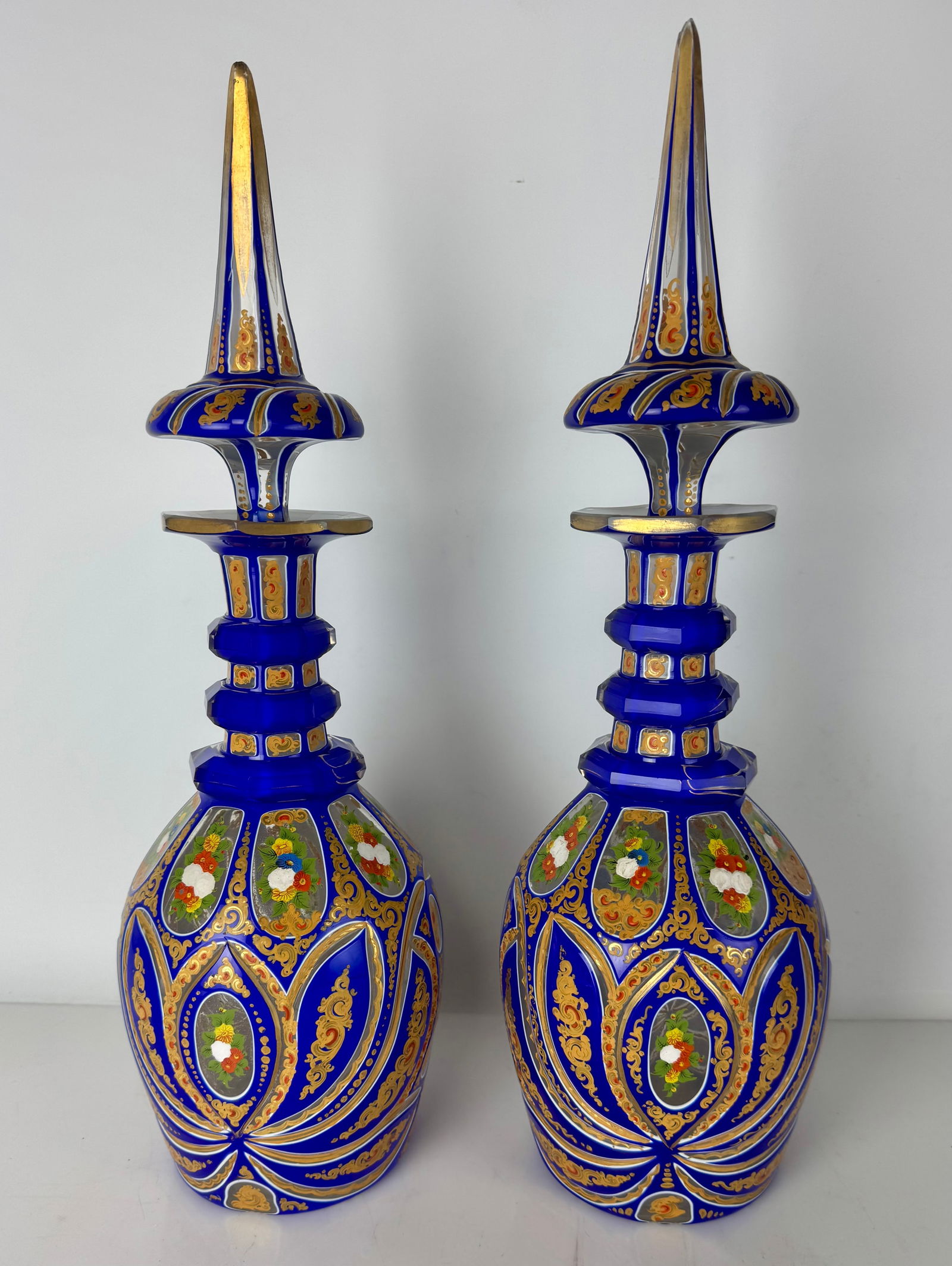 A PAIR OF PERSIAN TASTE BOHEMIAN BOTTLES AND TOPS