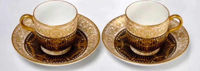 A PAIR OF JEWELLED ROYAL WORCESTER PORCELAIN CUP AND SAUCERS