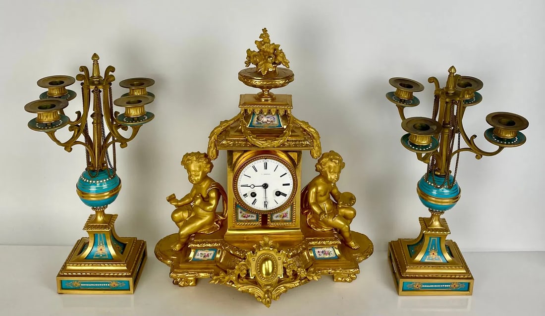 19TH C. ORMOLU MOUNTED SEVRES CLOCK SET: Clock measures 15 inches high. In good condition. Estimate $3000-4000