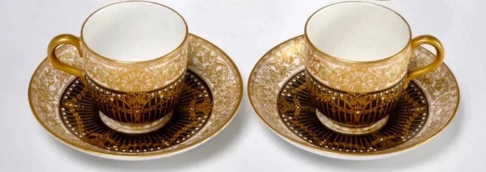 A PAIR OF JEWELLED ROYAL WORCESTER PORCELAIN CUP AND SAUCERS