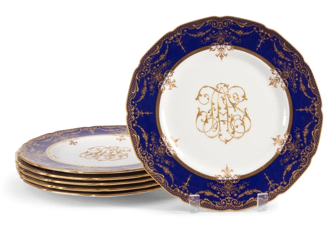 6ROYAL DOULTON DINNER PLATES: Circa 1930. raised gold floral decoration to a cobalt group with monogram to center, printed mark, dia. 10 1/4 in. Estimate $1000-1200