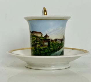 A CONTINENTAL TOPOGRAPHICAL PORCELAIN CUP AND SAUCER