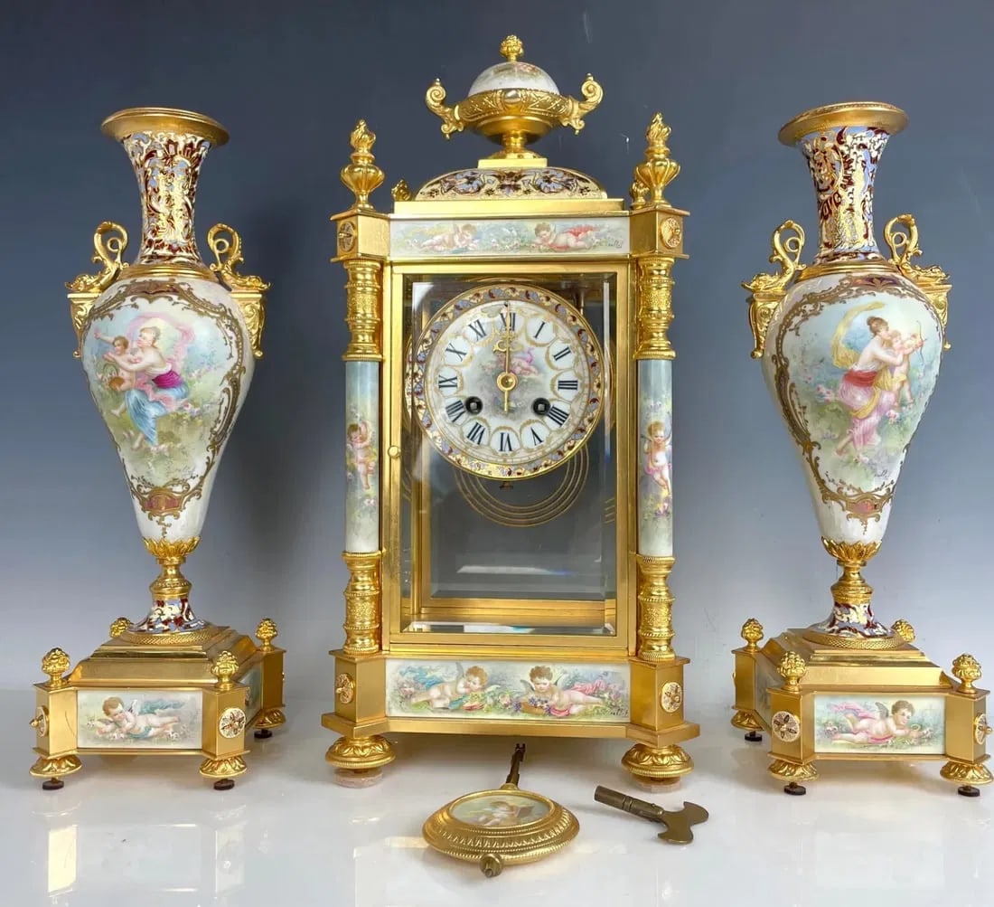 19TH C. FRENCH CHAMPLEVE ENAMEL AND SEVRES PORCELAIN CLOCK SET: Circa 1880. Clock measures 16.5 inches high x 8 inches l., 6 inches depth. In excellent condition. The clock movement works perfectly. Estimate $10.000-12.000