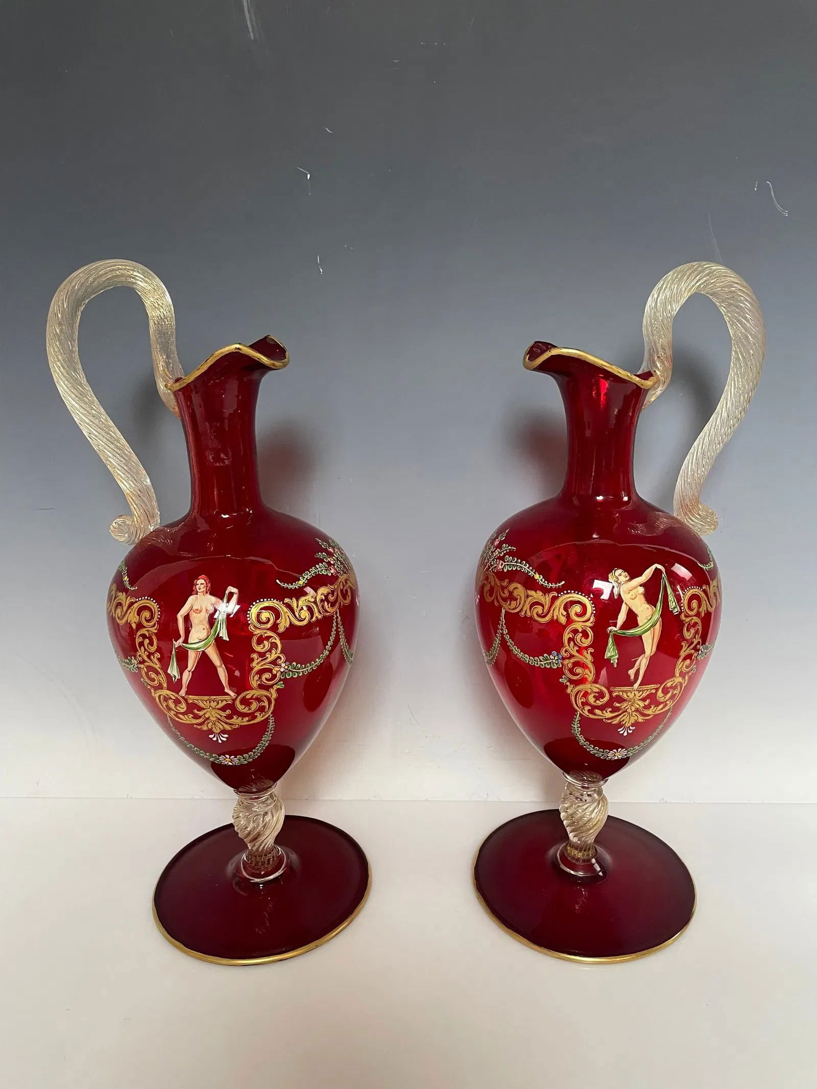 A PAIR OF ITALIAN ENAMELLED MURANO GLASS EWERS: Circa 1960. Measure 14 inches high. In excellent condition. Estimate $800-1000