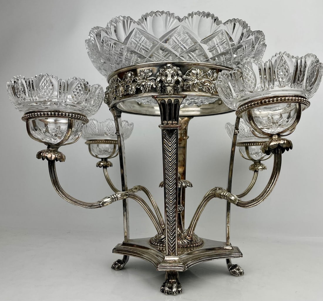 VICTORIAN SILVER PLATE EPERGNE BY MAPPIN AND WEB: Mappin Brothers Victorian Sheffield Silver Plate Epergne decorated with Lions heads and grape vines, and central finial with four removable arms holding cut glass bowls, on a base with four lions paws