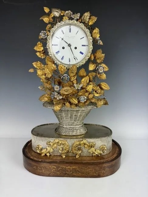 19TH C. MUSICAL CLOCK: Enamelled silvered and gilt metal clock. Plays music. Measures 24 inches high. In working condition.Estimate $2.000-2.500
