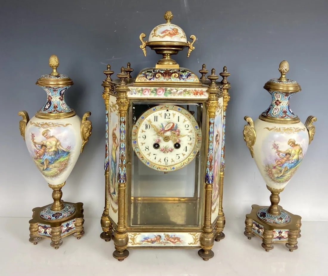 19TH C. FRENCHE SEVRES PORCELAIN AND CHAMPLEVE ENAMEL CLOCK SET: Clock measures 18 inches high, side pieces 14.5 inches high. In good condition, free of breaks and restoration. Estimate $6.000-8000