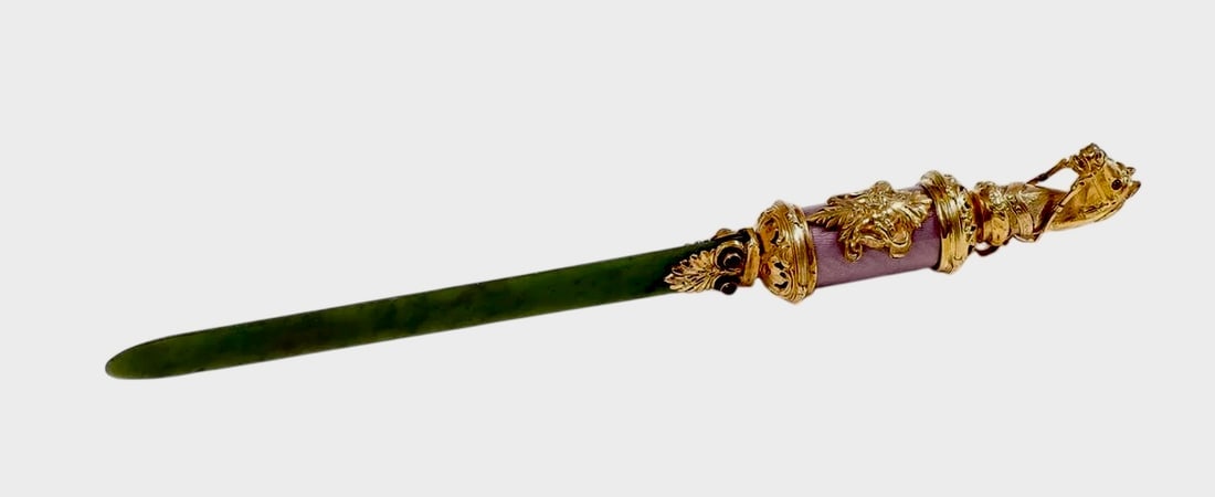 FABERGE STYLE SILVER GILT, ENAMEL AND NEPHRITE LETTER OPENER: SILVER GILT, ENAMEL AND NEPHRITE PAPER KNIFE. Comprising a finely crafted silver gilt, enamel and nephrite paper knife in the Fabergé style. The cylindrical handle with translucent mauve enamel over