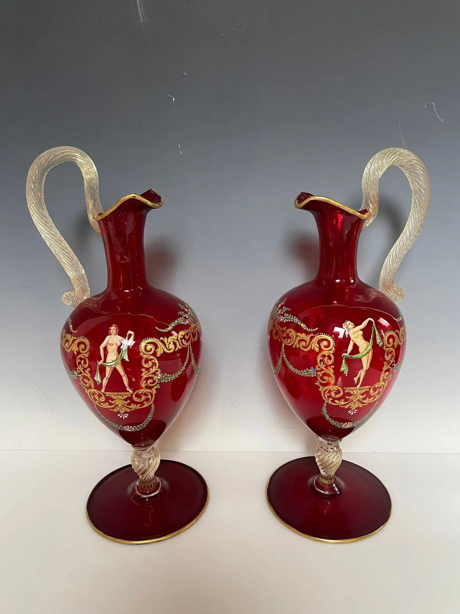 A PAIR OF ITALIAN ENAMELLED MURANO GLASS EWERS: Circa 1960. Measure 14 inches high. In excellent condition. Estimate $800-1000
