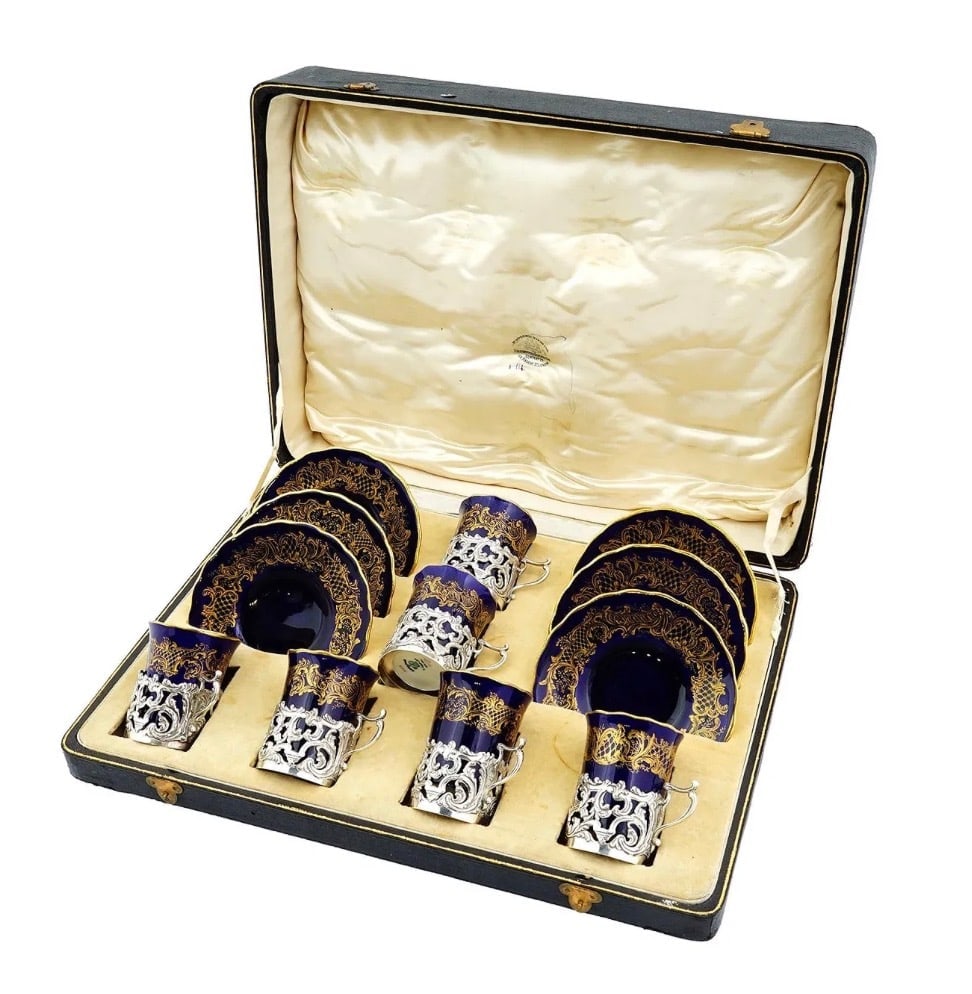 1899 GOLDSMITHS AND SILVERSMITHS SILVER CUPS W LINERS: Goldsmiths and Silversmiths set of 6 sterling silver cups with matching porcelain liners and saucers from 1899, with curvilinear motifs, in their original fitted box. Each china cup and saucer is mark