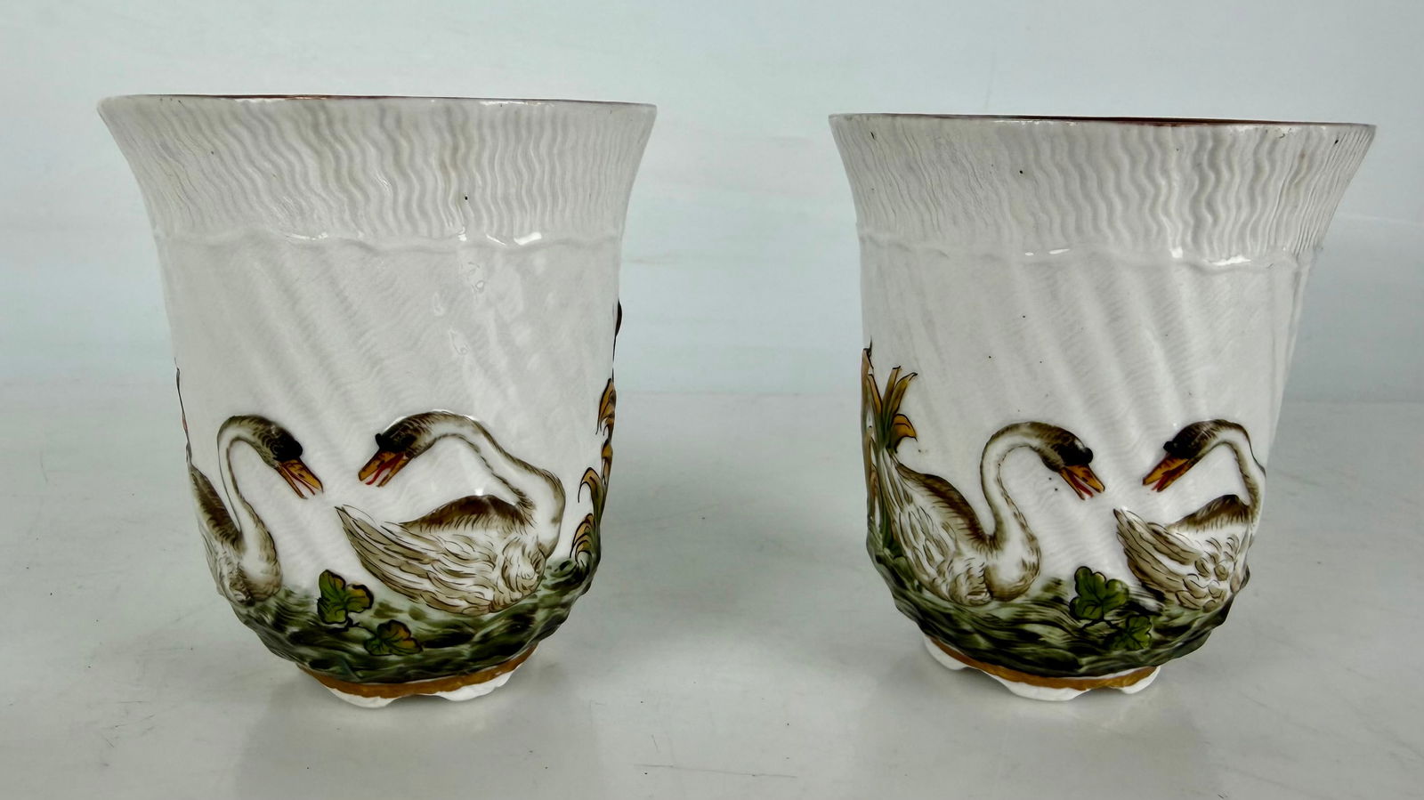 A PAIR MEISSEN TEA CUPS SWAN PATTERN: Circa 1900. Measure 4” h. In excellent condition. Estimate $500-600
