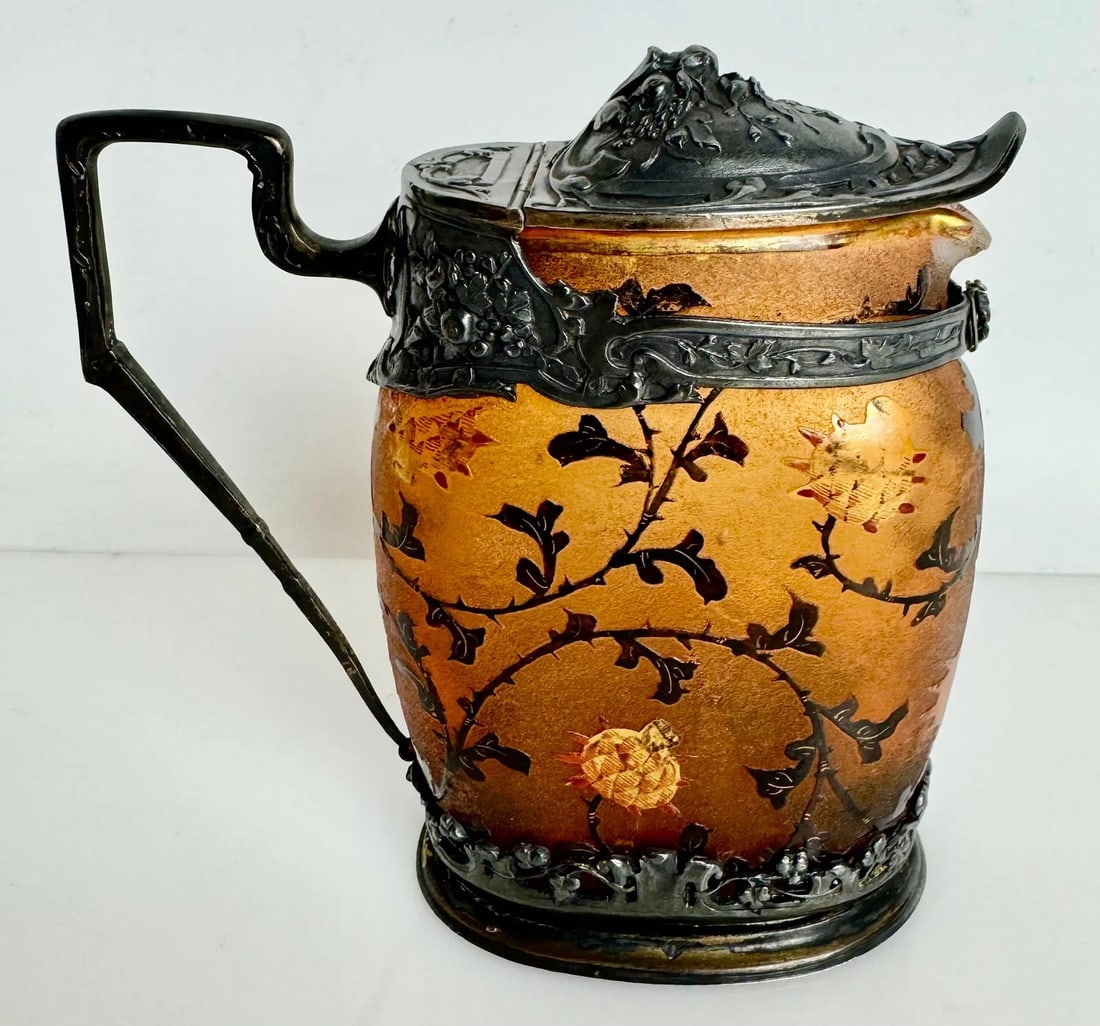 ENAMELLED AND GILT SILVER MOUNTED DAUM NANCY EWER: Circa 1900. Measures :4 1/2 inches high and 4 3/8 inches from handle to spout Excellent condition, minor loss of age related gold. Silver hallmarked. Estimate $2000-2500