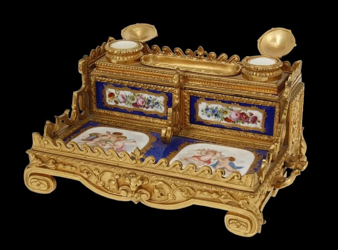 FRENCH DORE BRONZE AND SEVRES STYLE PORCELAIN INKWELL: Circa 1900. Measures 11 inches long. Estimate $1.500-2.000