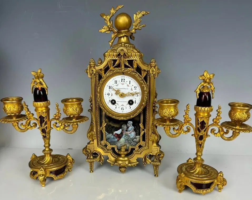 FRENCH DORE BRONZE AND ENAMEL CLOCK GARNITURE: Circa 1900. Clock measures 12 inches high. In good condition. Estimate $2.000-2.500