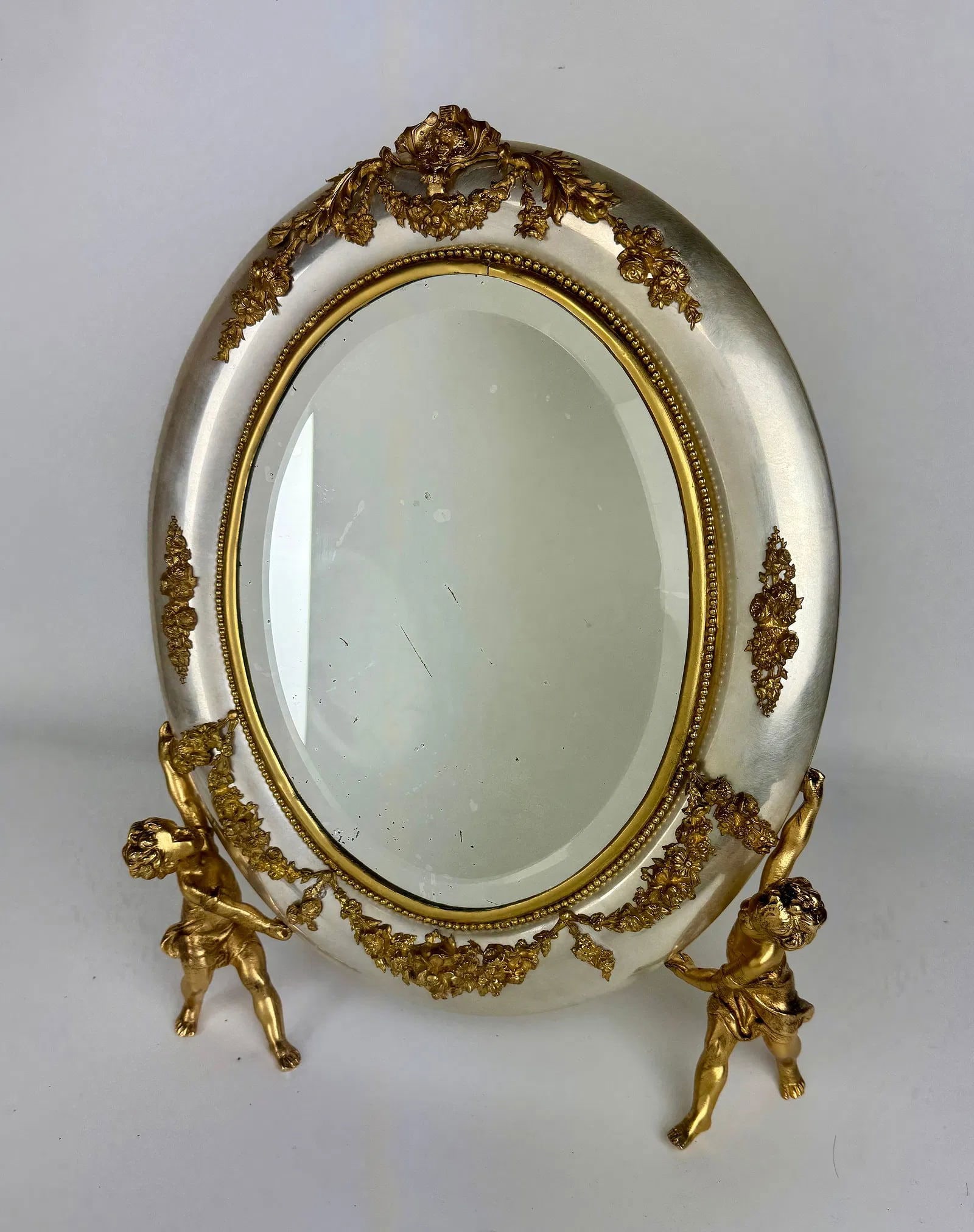 A VERY UNUSUAL GILT AND SILVERED ORMOLU MIRROR: Circa 1900. Measures 16 inches h. In good antique condition. Estimate $1500-2000