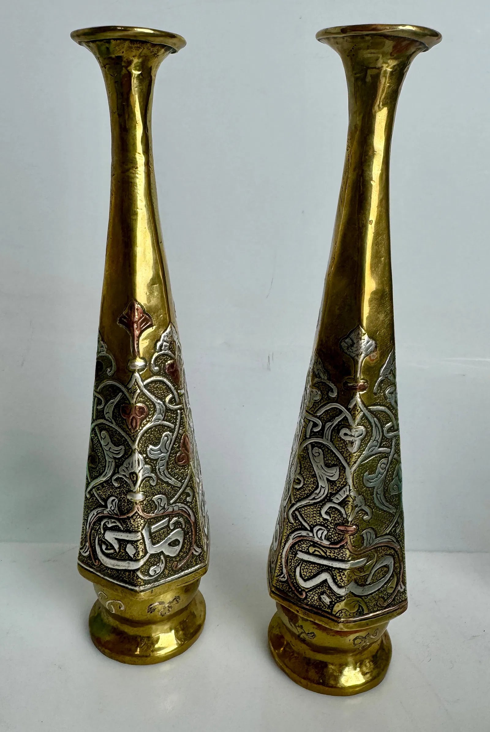 A PAIR OF ISLAMIC SILVER AND COPPER INLAID VASES: Circa 1940. Measures 9.5 inches high. In good condition. Estimate $600-800