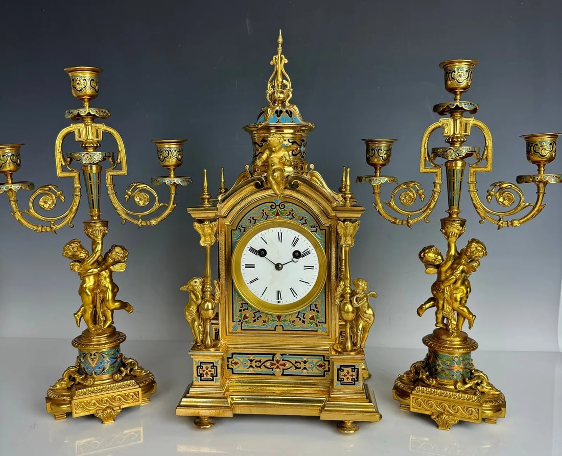 19TH C. FRENCH CHAMPLEVE ENAMEL BRONZE CLOCK SET: Clock measures 17.5 inches high, candelabra 15 inches high. In good antique condition.Estimate $4500-5000