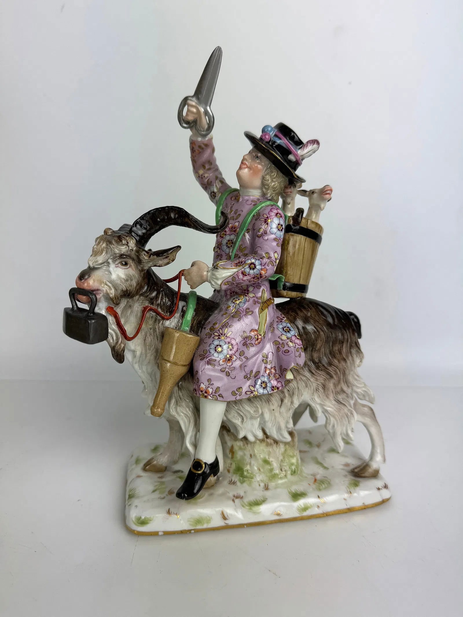 19TH C. MEISSEN PORCELAIN GROUP OF TAYLOR RIDING GOAT: First quality cross swords mark. Measures 10 inches h. In good condition, minor professional restrictions. Estimate $1509-2000