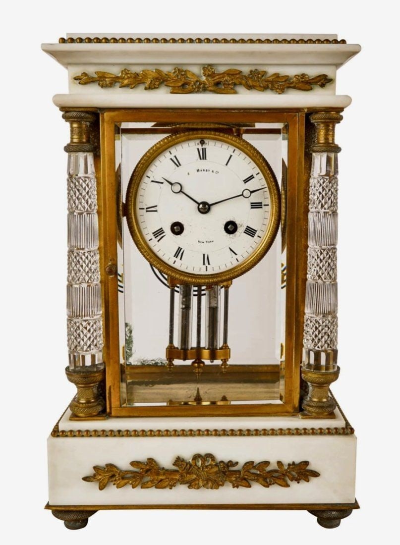 EMPIRE STYLE DORE BRONZE MARBLE AND CRYSTAL CLOCK: dial signed inches Manby & Co. / New York inches Condition: working condition unknown. A loss to marble at right rear corner 8 1/2 inches wide; 5 1/2 inches deep; 13 1/2 inches highEstimate &800-1.000