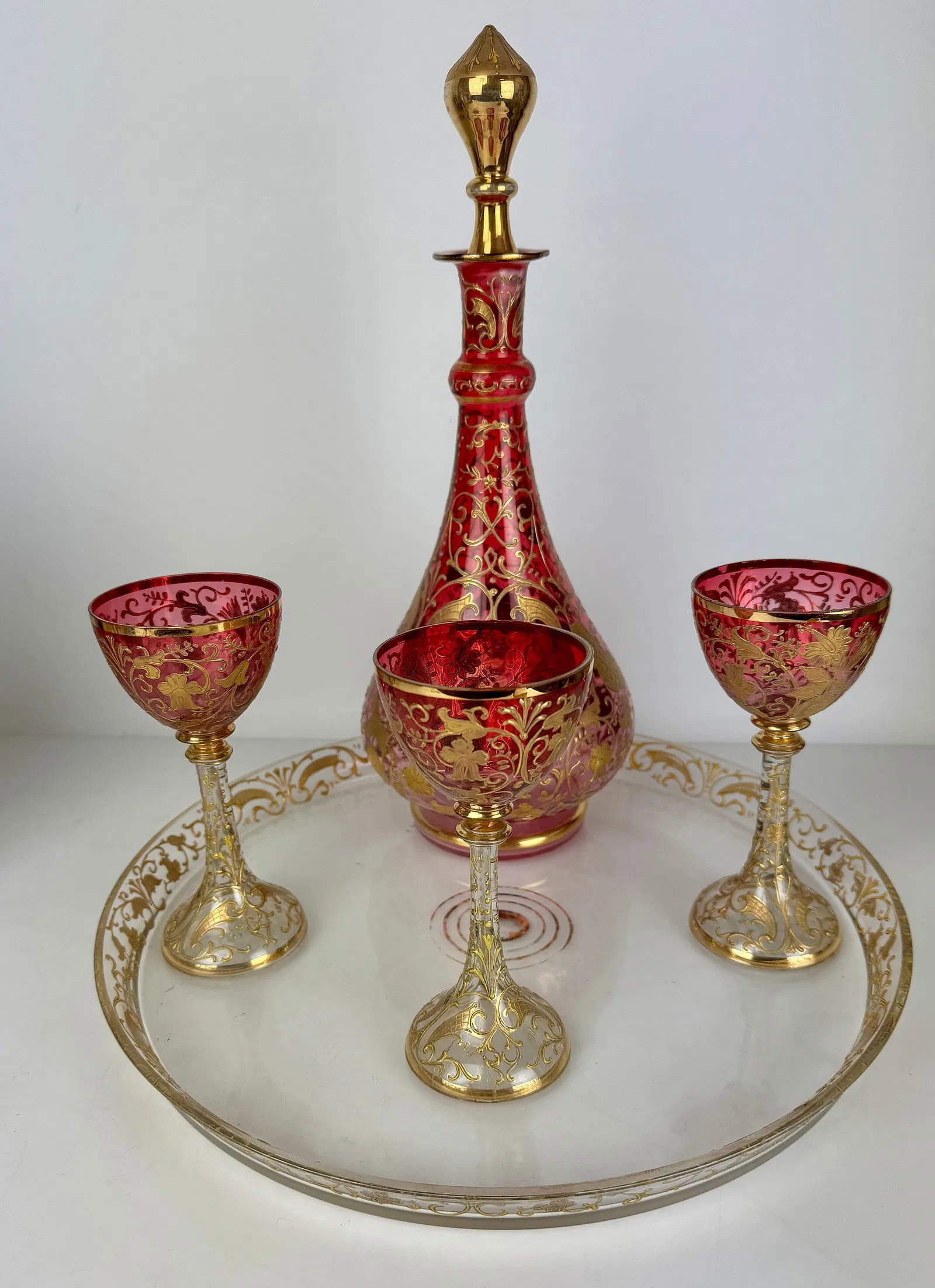 ENAMELLED AND GILT MOSER LIQUOR SET: Comprising of a tray, liquor bottle and 3 glances. Tray 13 inches d. All in perfect condition. Estimate $800-1000