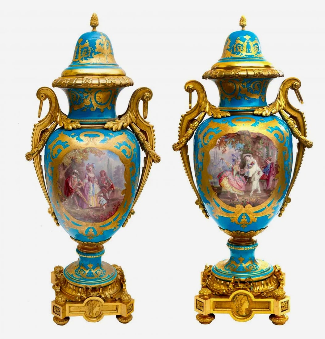 A PAIR OF MONUMENTAL FRENCH SEVRES STYLE ORMOLU-MOUNTED VASES: LATE 19TH CENTURYeach of baluster form, two-handled, the handles formed as scrolling acanthus leaves and laurels with suspensions, the turquioise body centered with a cartouche depicting scenes of cou