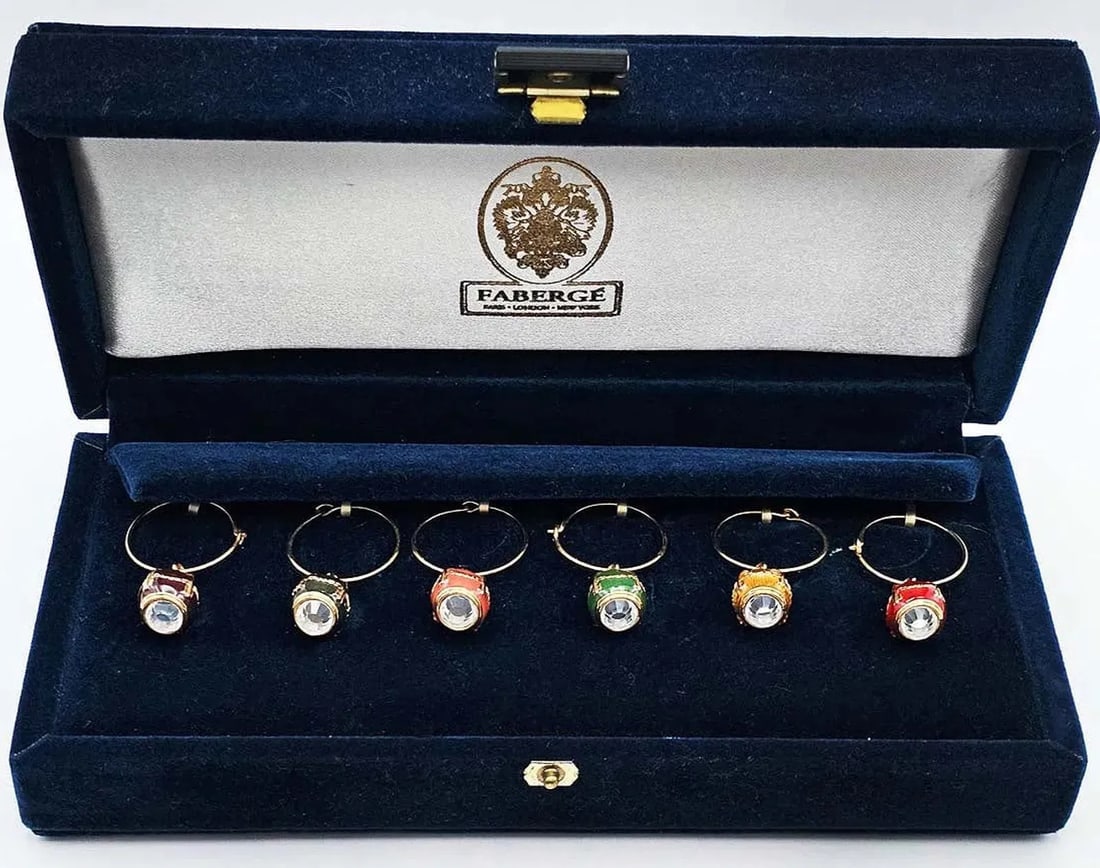 IMPERIAL FABERGE GOLD PLATED ENAMEL EGG WINE CHARMS: Faberge Imperial Gold Plated Enamel Egg Colorful Wine Charms, in original presentation box.Estimate $500-600