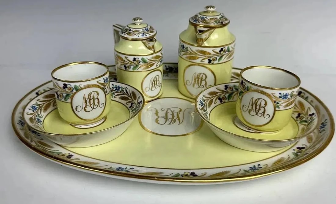 A VIENNA PORCELAIN CHOCOLATE SET CIRCA 1803: Comprising of tray 12 inches long, 2 cups and saucers, chocolate pot, and hot water pot , stamped 803 and beehive marks. All in good condition. Estimate $2.500-3.000