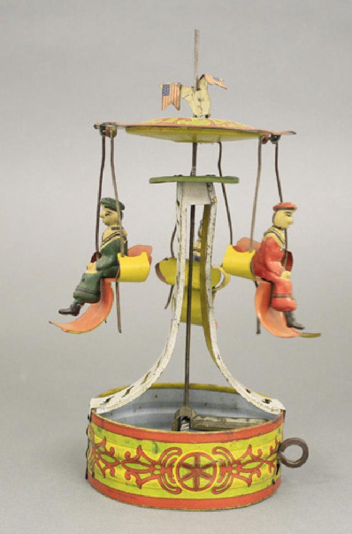 Fairground Ride with Chair Seats: Marked “ Made in USA” Circa 1920’s - 10” Tall Bright and attractive lithography make this a very pleasing toy to play with. Works quite well. Material: Tin