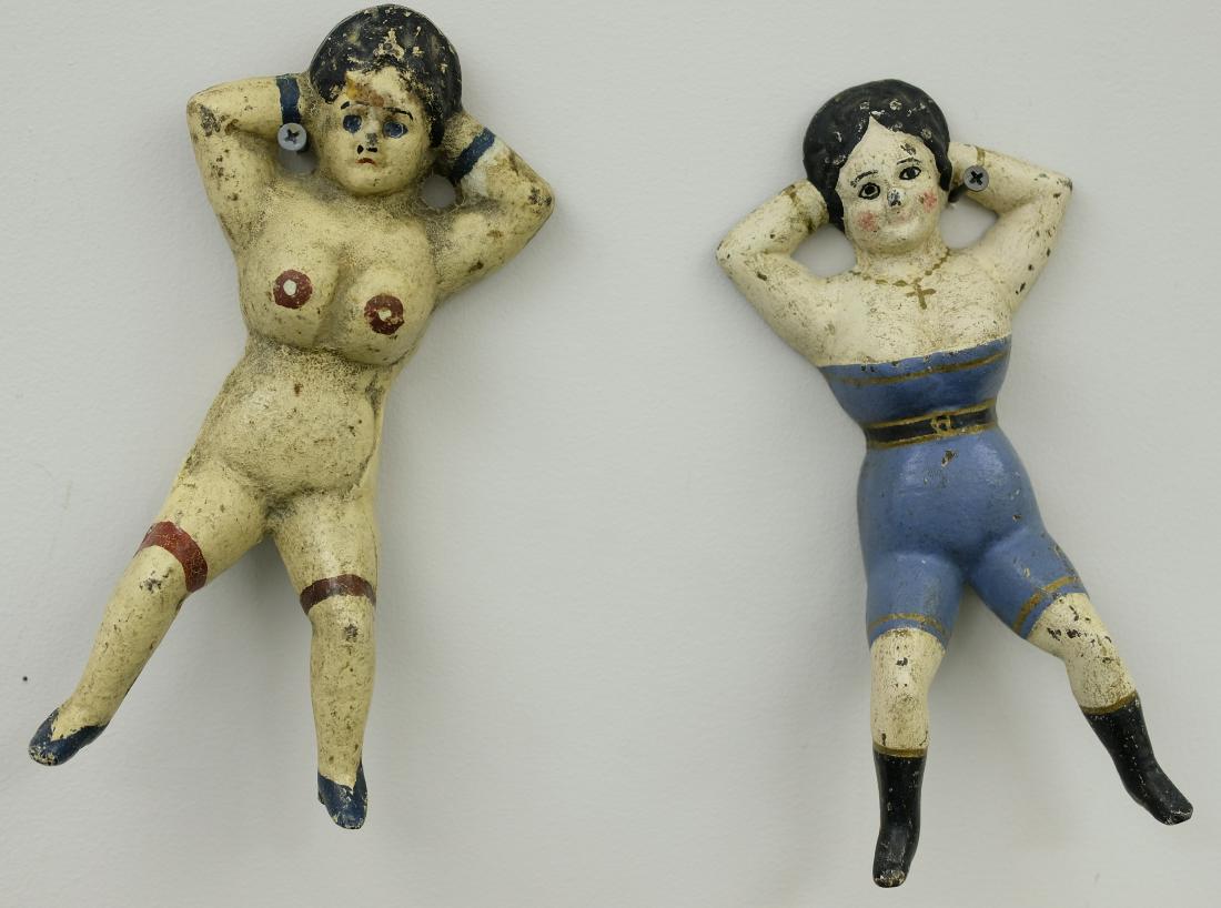Two Naughty Nellie Boot Jacks: American - Circa 1890's One is a religious gal wearing her cross and only showing half her bosoms the other fully nude. Cast Iron